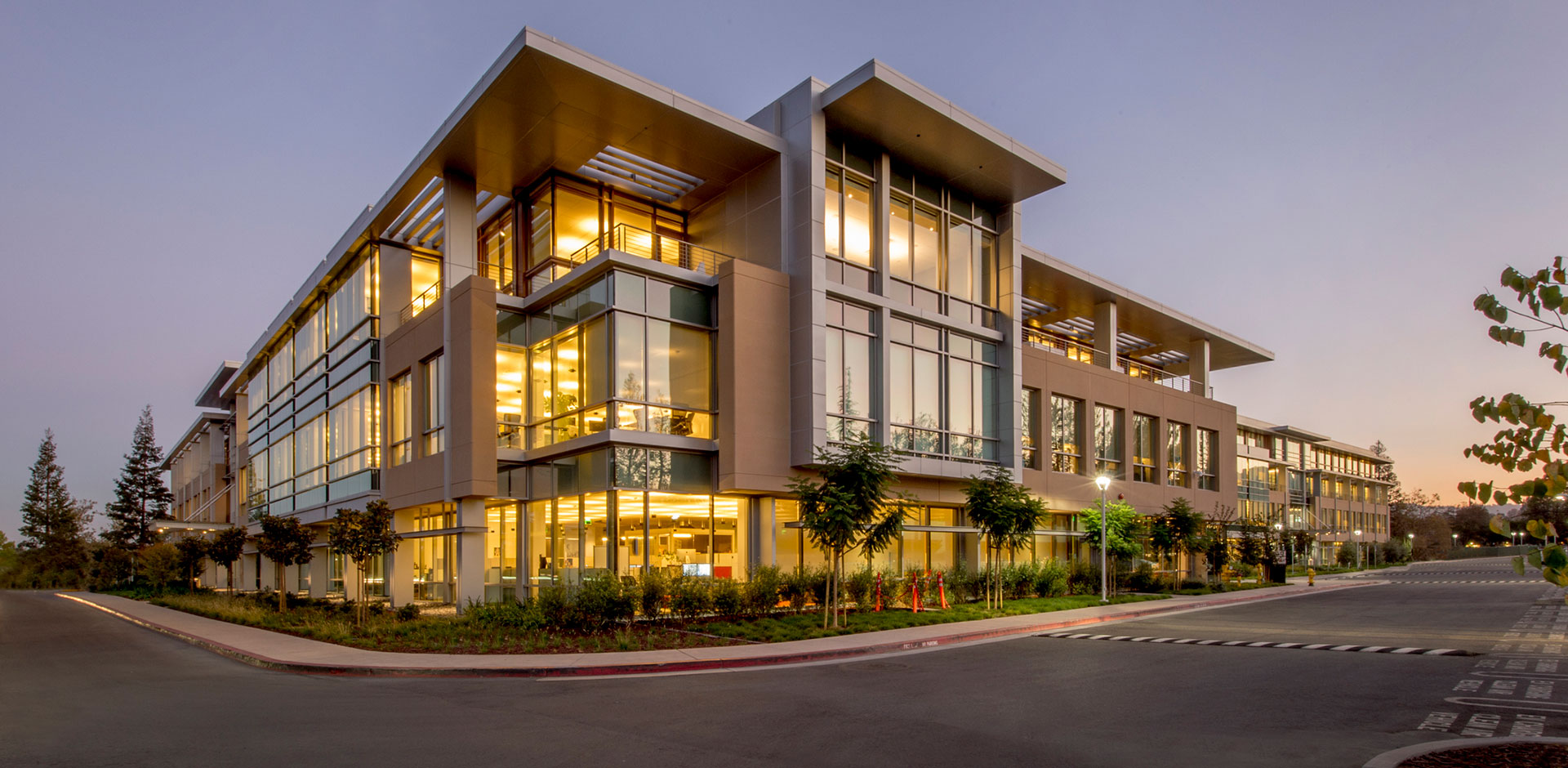 Commercial building exterior with illuminated windows at dusk